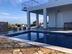 a swimming pool in front of a house at Villa Peony Koroni in Koroni