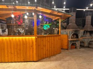 a wooden bar with a fish tank in front of a building at Guest House Sakollari in Poliçan