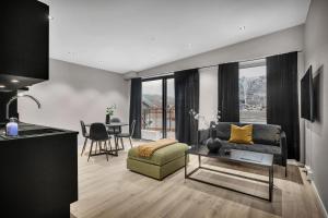 uma sala de estar com um sofá e uma mesa em TA Vervet Apartment Hotel em Tromsø