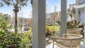 un porche con 2 sillas y una palmera en Landing Modern Apartment with Amazing Amenities (ID9801X81) en Tampa
