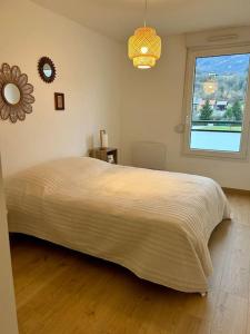 Un dormitorio con una cama grande y una ventana en Superbe appartement T3 en résidence avec piscine, en Albertville