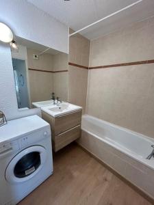 a bathroom with a washer and a sink and a washing machine at Superbe appartement T3 en résidence avec piscine in Albertville