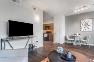un soggiorno con una grande TV a schermo piatto di Landing Modern Apartment with Amazing Amenities (ID2956X24) ad Austin