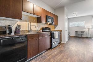 una cucina con armadi in legno e piano di lavoro di Landing Modern Apartment with Amazing Amenities (ID2956X24) ad Austin