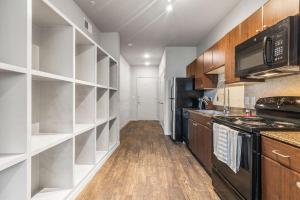 una cucina con scaffali bianchi ed elettrodomestici neri di Landing Modern Apartment with Amazing Amenities (ID2956X24) ad Austin