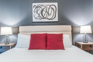 una camera con un letto bianco e un cuscino rosso di Landing Modern Apartment with Amazing Amenities (ID2956X24) ad Austin