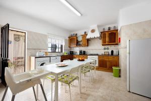 a kitchen with a table and chairs and a refrigerator at Casa Brita in Raposeira