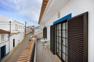 a balcony with a table and a view of a street at Casa Brita in Raposeira