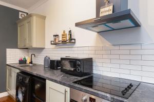 a kitchen with a counter top with a microwave at Modern abode with Free Parking and Smart TV in Bedworth, Near M6 & George Eliot Hospital in Bedworth