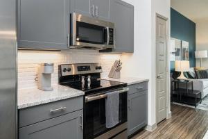 a kitchen with a stove and a microwave at Landing Modern Apartment with Amazing Amenities (ID3378X75) in Pompano Beach