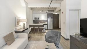 uma sala de estar com um sofá branco e uma cozinha em Landing Modern Apartment with Amazing Amenities (ID1227X465) em Cambridge