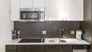 uma cozinha com um lavatório e um micro-ondas em Landing Modern Apartment with Amazing Amenities (ID1227X465) em Cambridge