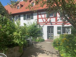 a white and red house with a table and chairs at Ferienhof Klein in Gunzenhausen