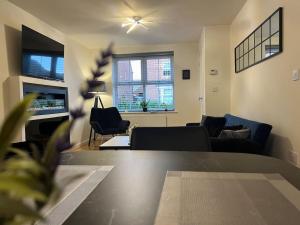 ein Wohnzimmer mit einem Sofa und einem Tisch in der Unterkunft Braid House in Loughborough