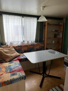 a living room with a table and a bed at Mobile Home Italy in Porlezza