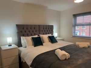 a bedroom with a large bed with a large headboard at Braid House in Loughborough