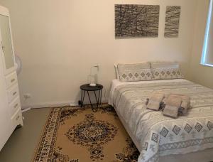 a bedroom with a bed with a table and a rug at Ocean Vista Beach Stay in Rockingham