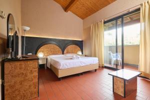 sypialnia z łóżkiem i dużym oknem w obiekcie Hotel Zì Martino w mieście Castagneto Carducci