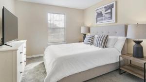 Habitación blanca con cama y TV en Landing Modern Apartment with Amazing Amenities (ID1402X064), en Slidell