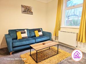 a living room with a blue couch and a table at The Clevedon Bungalow , Close to Sea Front, Great Locataion in Weston-super-Mare