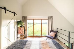 a bedroom with a bed and a large window at Het Landzicht 