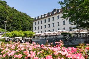 a large building with pink flowers in front of it at Grand Hôtel & Spa Uriage in Uriage-les-Bains