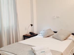 a bedroom with a white bed with towels on it at K12 Hotel in Barrancabermeja