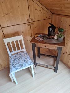une table en bois avec une chaise à côté d'un mur en bois dans l'établissement Urlaubstraum, à Sankt Veit an der Glan