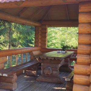 uma cabina de madeira com uma mesa num deque em Садиба Урочище Луг em Vorokhta