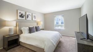 1 dormitorio con 1 cama y TV de pantalla plana en Landing Modern Apartment with Amazing Amenities (ID1008X640) en Homewood