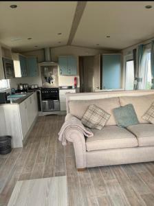 a living room with a couch and a kitchen at GDs Luxury Caravan Hire Turnberry Holiday Park in Turnberry