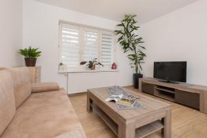 a living room with a couch and a tv at Beautiful Apartments in a Quiet Area of Gdynia by Renters in Gdynia