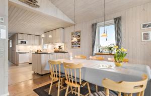 a kitchen and dining room with a table and chairs at Holiday Home Henriettevej Hvide Sande Ix in Bjerregård