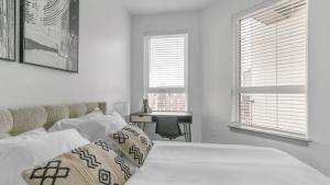 een witte slaapkamer met een bed en 2 ramen bij Landing Modern Apartment with Amazing Amenities (ID1783X42) in Richmond
