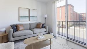 een woonkamer met een bank en een tafel bij Landing Modern Apartment with Amazing Amenities (ID1791X17) in Richmond