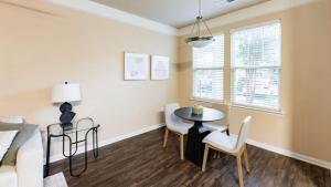 uma sala de estar com uma mesa e cadeiras e uma janela em Landing Modern Apartment with Amazing Amenities (ID4344X54) em Goose Creek