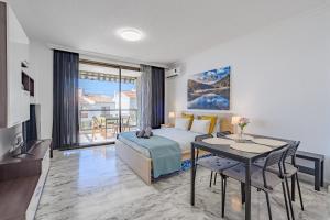 um quarto com uma cama, uma mesa e uma sala de jantar em Beauty of Nature Apartment El Lago em Puerto de Santiago