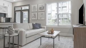 un soggiorno bianco con divano e tavolo di Landing Modern Apartment with Amazing Amenities (ID1208X667) a Decatur