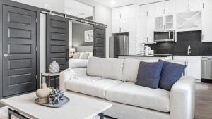 Landing Modern Apartment with Amazing Amenities (ID1208X667) في ديكاتور: غرفة معيشة مع أريكة بيضاء ومطبخ