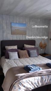 a bedroom with a large bed with pillows at LA MESONNETTA in Soulignonne