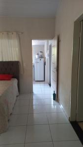 um quarto com piso branco e uma cozinha com frigorífico em Refúgio Serrano em Martins