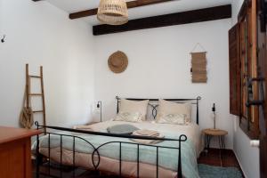 1 dormitorio con 1 cama con marco de hierro forjado en La Granja de Antonio en Alhaurín el Grande