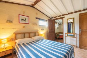 1 dormitorio con 1 cama con manta de rayas azul y blanco en Le Cottage - Gîtes De La Tournerie, en Gémozac