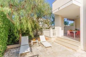 un patio con dos sillas y una mesa en Villa Brigida a Torre Santa Sabina, en Torre Santa Sabina