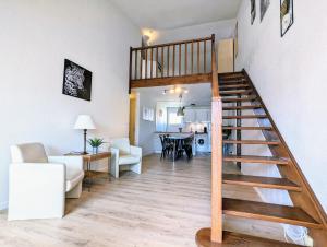 a living room and dining room with a spiral staircase at Appartement T4, climatisation, 50m de la plage in Cap d'Agde