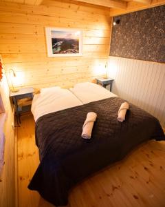 een slaapkamer met een groot bed in een houten kamer bij BLUEBERRY LODGE 5 personnes in Mjölan