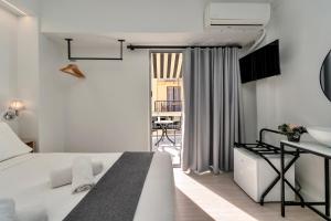 a white bedroom with a bed and a sink at Hotel Adonis Athens in Athens