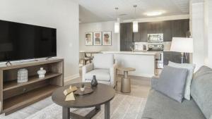 ein Wohnzimmer mit einem Sofa und einem Tisch sowie eine Küche in der Unterkunft Landing Modern Apartment with Amazing Amenities (ID1002X885) in Wake Forest