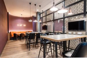 a dining room with tables and chairs and a flat screen tv at Premier Inn Hamburg St. Pauli in Hamburg