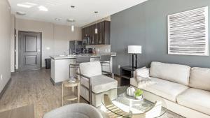 a living room with a white couch and a kitchen at Landing Modern Apartment with Amazing Amenities (ID3676X65) in Perrysburg